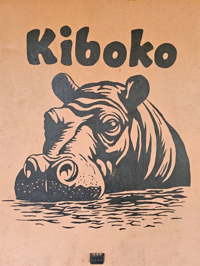 Hand-painted hippo mural with the name Kiboko on a Camp Wildside cabin wall