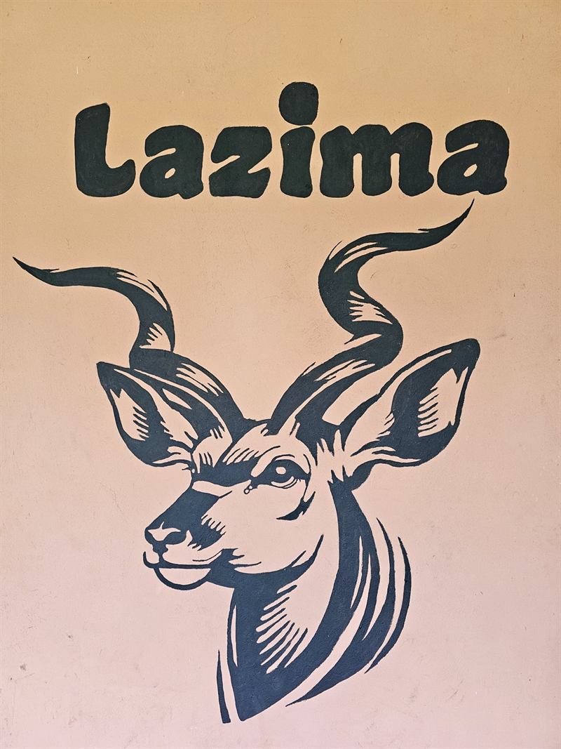 Hand-painted kudu mural with the name Lazima on a Camp Wildside cabin wall