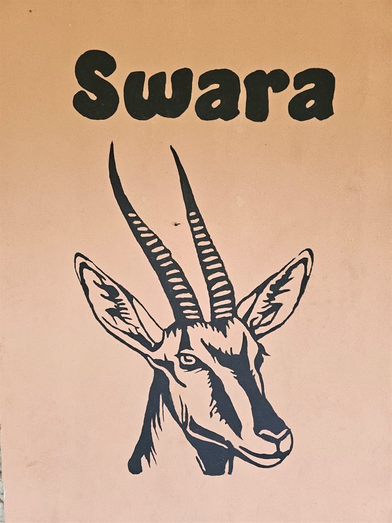 Hand-painted gazelle mural with the name Swara on a Camp Wildside cabin wall